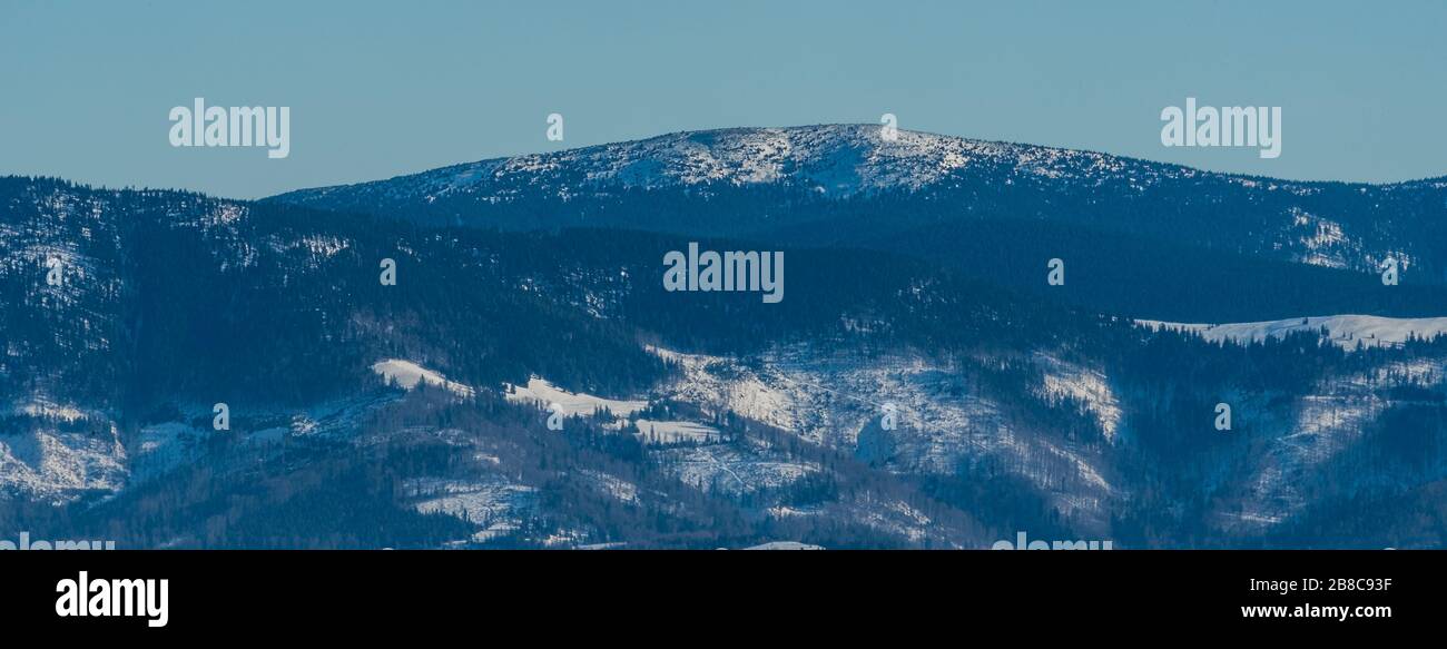 Colline de Pilsko dans les montagnes d'Oravske Beskydy en Slovaquie depuis la colline de Barania Gora dans les montagnes de Beskid Slaski en Pologne pendant la journée d'hiver avec ciel clair Banque D'Images