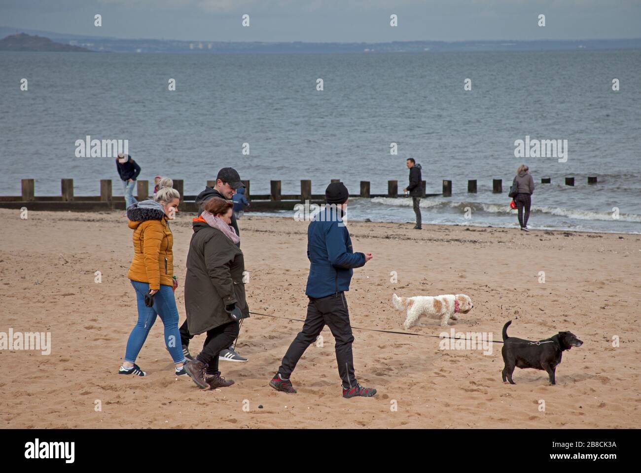 Portobello, Édimbourg, Écosse, Royaume-Uni. 21 mars 2020. Temps calme et public continuer comme normal. L'Ecosse a eu 51 nouveaux cas de Coronavirus qui porte le total à 373, un autre décès au jour le jour porte le total à 7. Le public continue de se rassembler et d'avoir une interaction sociale comme d'habitude. Avec les pubs locaux qui sont fermés comme l'a conseillé le gouvernement et le café de la plage qui prend à l'écart par un service de fenêtre, seulement deux jeunes portant visiblement des masques semblent prendre la menace du virus au sérieux. Banque D'Images