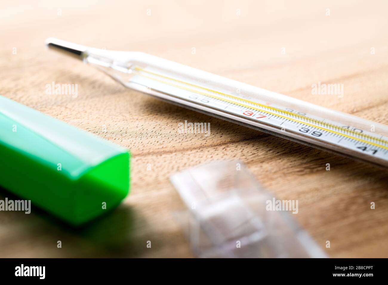 Thermomètre sur table en bois avec paquet. Mesure de la température corporelle dans les soins de santé et les affaires médicales. Avoir de la fièvre, de la grippe, de la maladie, du virus. Banque D'Images