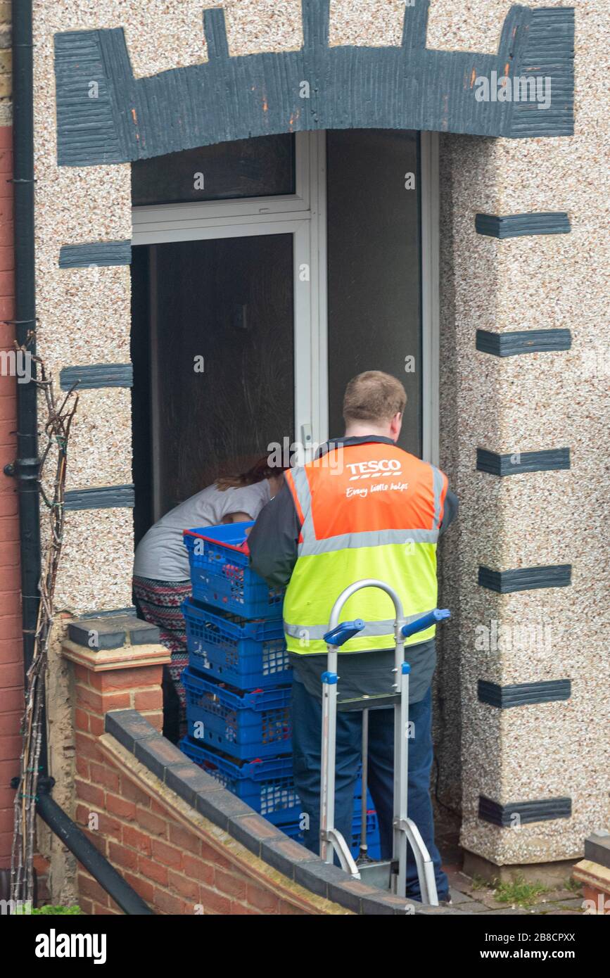 Un chauffeur de livraison Tesco livrant une pile de boîtes d'épicerie à une propriété de Westcliff on Sea, Essex, au Royaume-Uni, pendant l'éclosion de Coronavirus de COVID-19 Banque D'Images