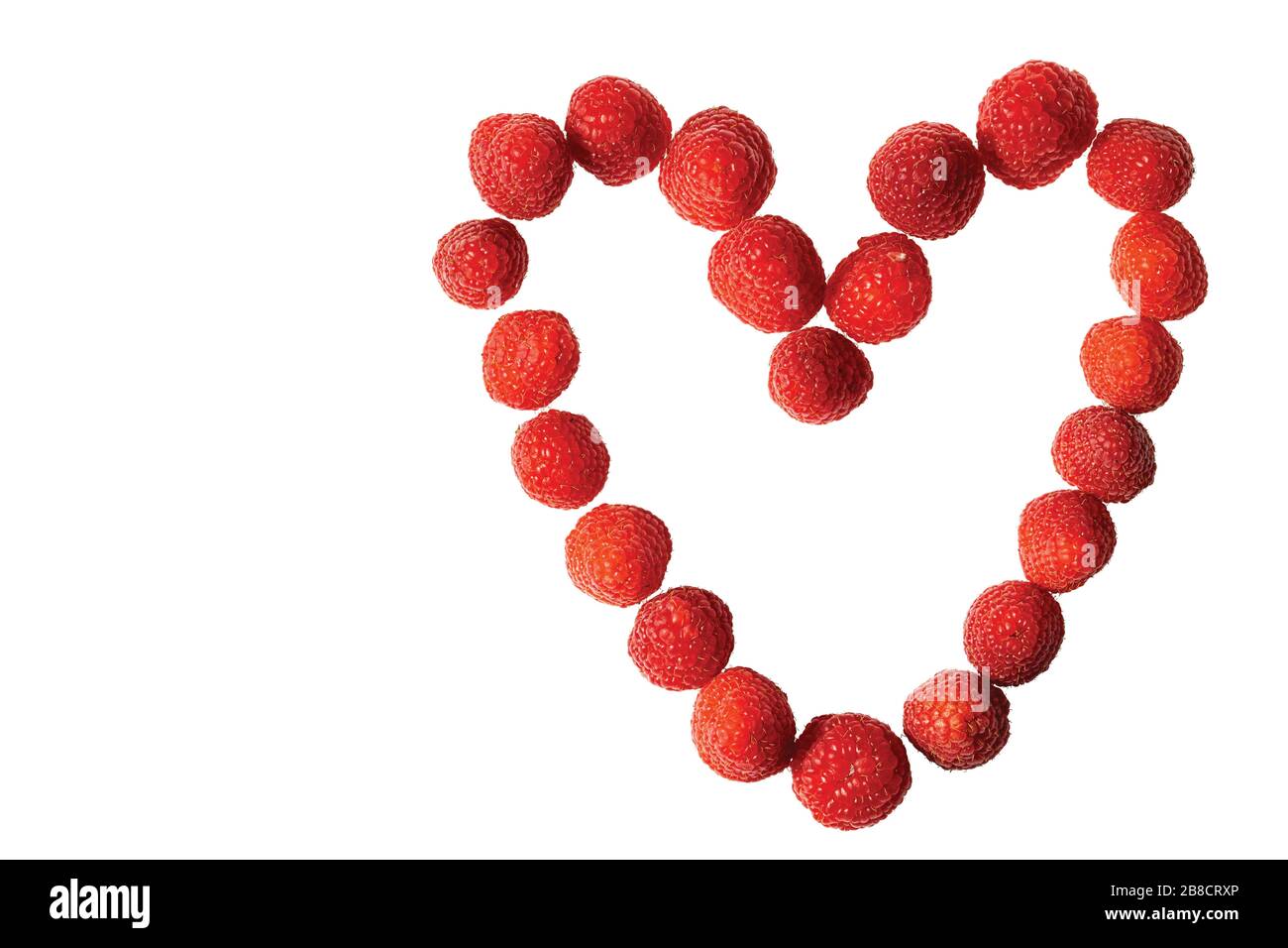 Vue rapprochée de la figure en forme de coeur bordée de framboises rouges. Saint Valentin. Concept d'amour. Banque D'Images