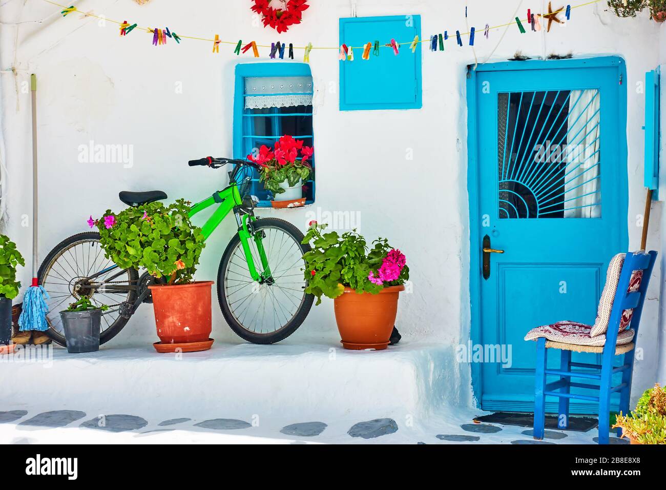 Rue avec maison blanchie à la chaux et vélo près du mur sur l'île de Mykonos, Grèce Banque D'Images