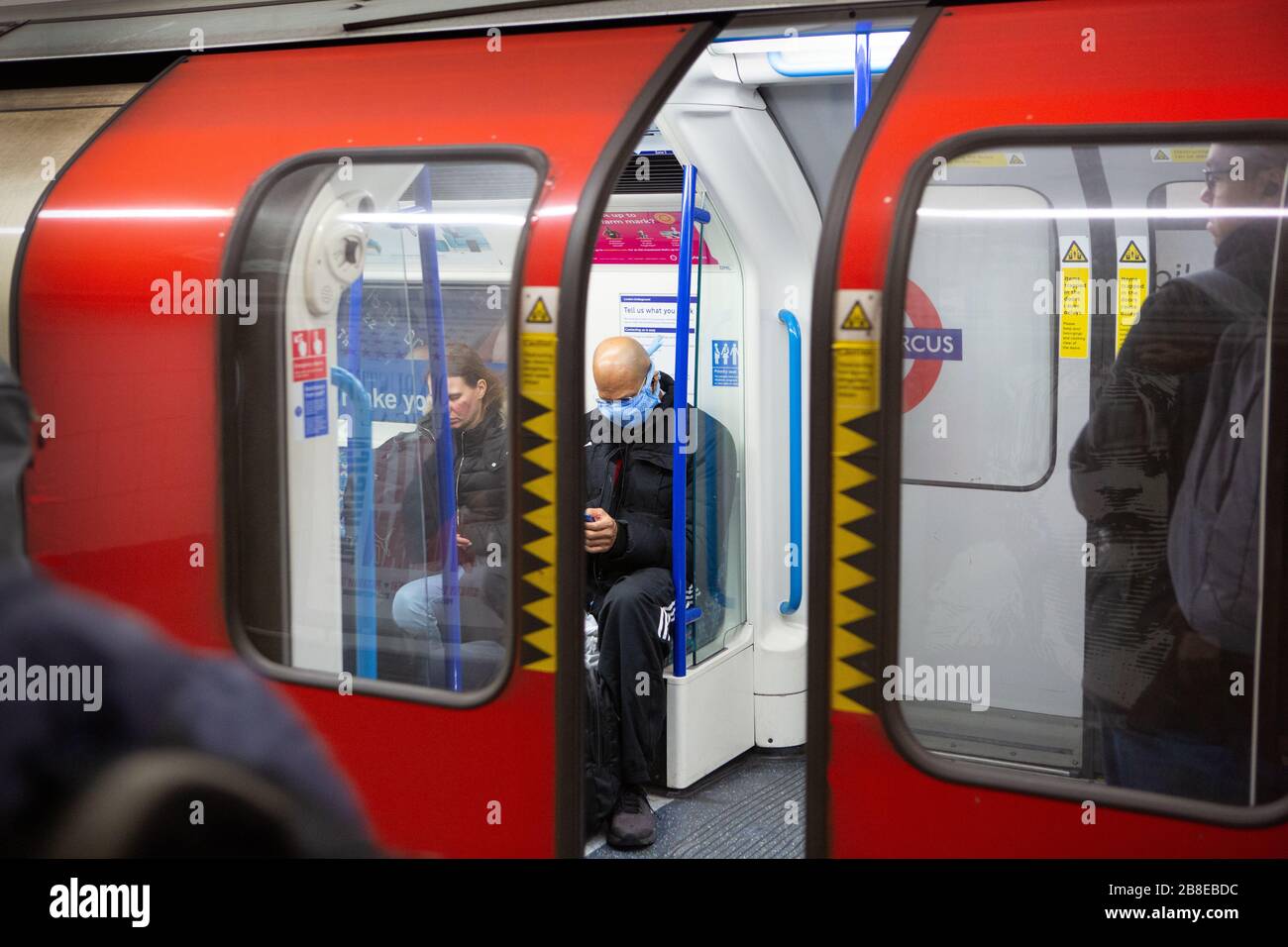 Navetteurs avec masques faciaux dans le métro de Londres pendant le verrouillage du coronavirus, mars 2020 Banque D'Images