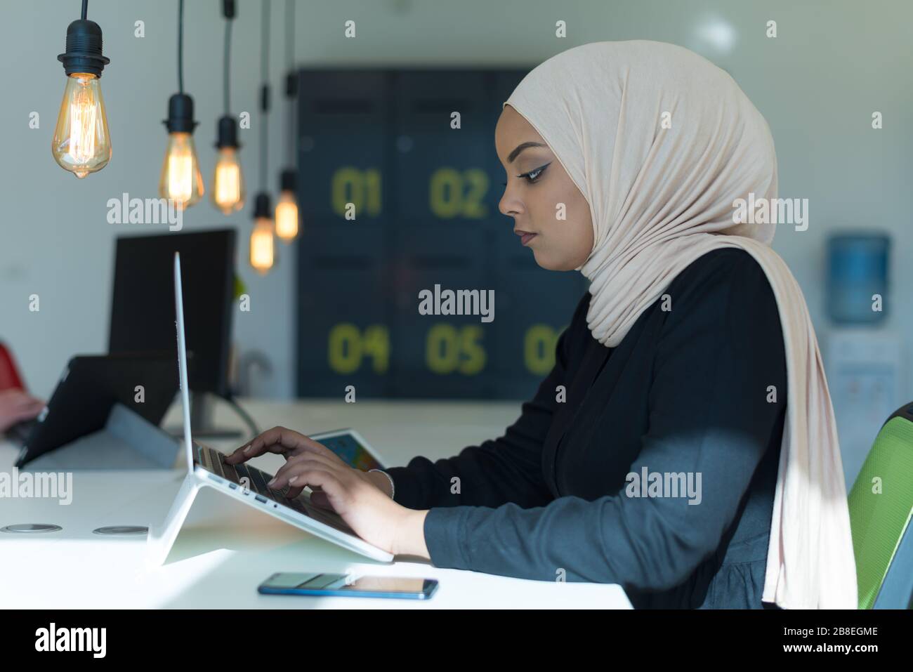 Jeune femme d'affaires musulmane africaine américaine comme leader au travail. Travail d'équipe et concept multiethnique. Bonne responsable d'entreprise qui travaille chez elle Banque D'Images