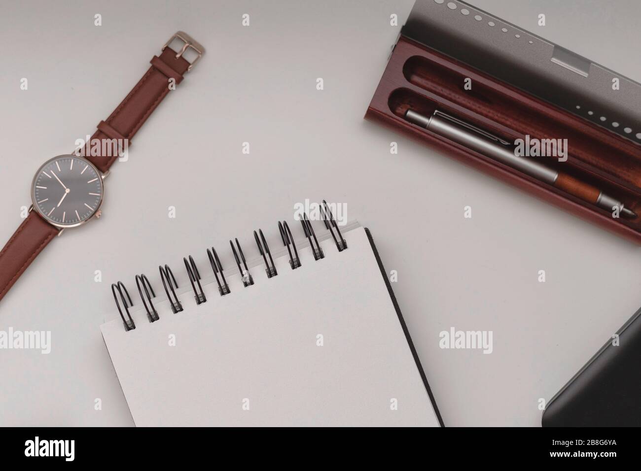 Arrière-plan minimaliste de l'espace de travail, ordinateur portable en spirale ouvert avec feuille vierge, stylo et téléphone portable. Espace de copie vue de dessus, plat, maquette. Banque D'Images