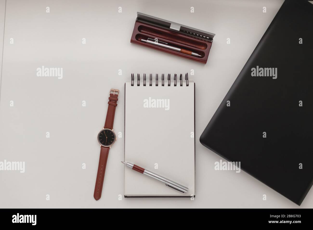 Arrière-plan minimaliste de l'espace de travail avec ordinateur portable, stylo, étui à stylet, montre au poignet et ordinateur portable. Bureau blanc. Travail, affaires, concept freelance. C Banque D'Images