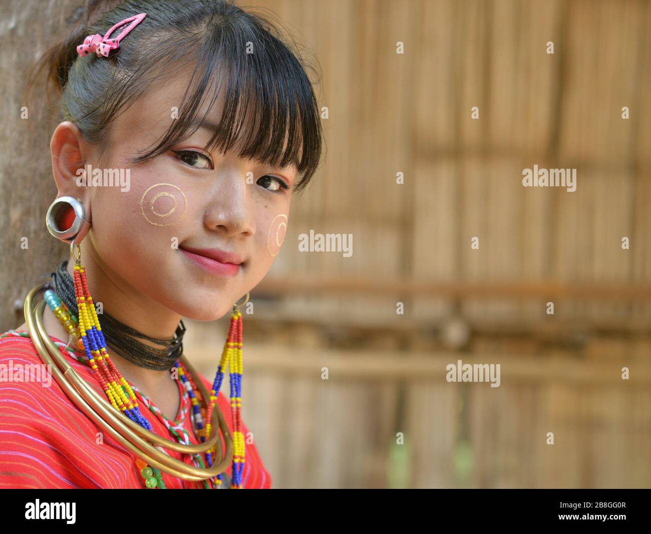 Jolie Karen Kayaw (Karen Kayor) adolescente avec le visage de thanaka cosmétique sur ses joues et des bouchons d'oreilles tribales distinctifs pose pour la caméra. Banque D'Images