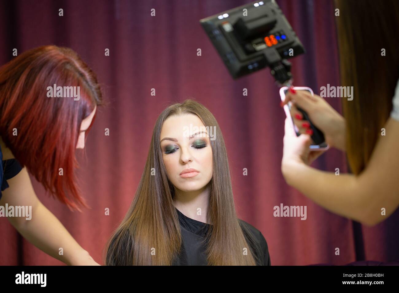 Les artistes de maquillage prennent des photos du modèle après leur travail Banque D'Images