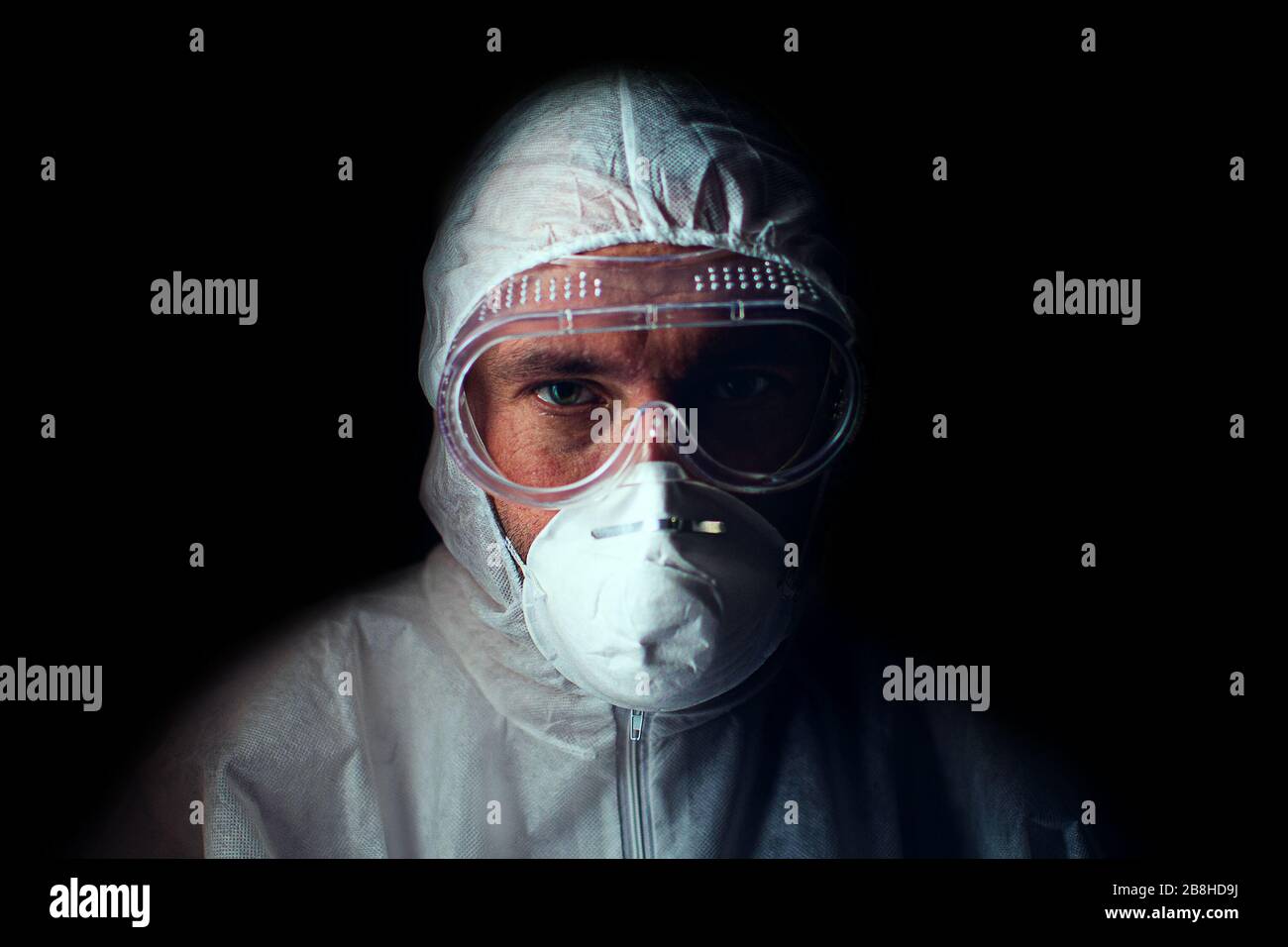 Médecin avec un regard fatigué dans un respirateur, des lunettes et un costume de protection bactériologique. Touche Bas. Concept de dévouement à la profession médicale. Banque D'Images