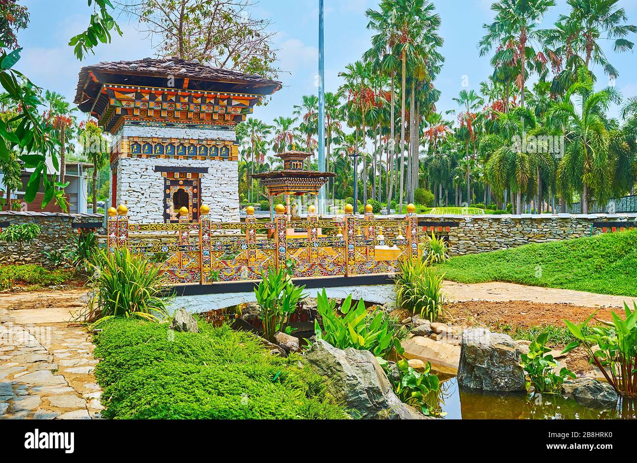 Le pittoresque sanctuaire bhoutanais et le pont sculpté sont cachés dans une végétation luxuriante du jardin du Bhoutan, du parc Rajaruek, Chiang Mai, Thaïlande Banque D'Images