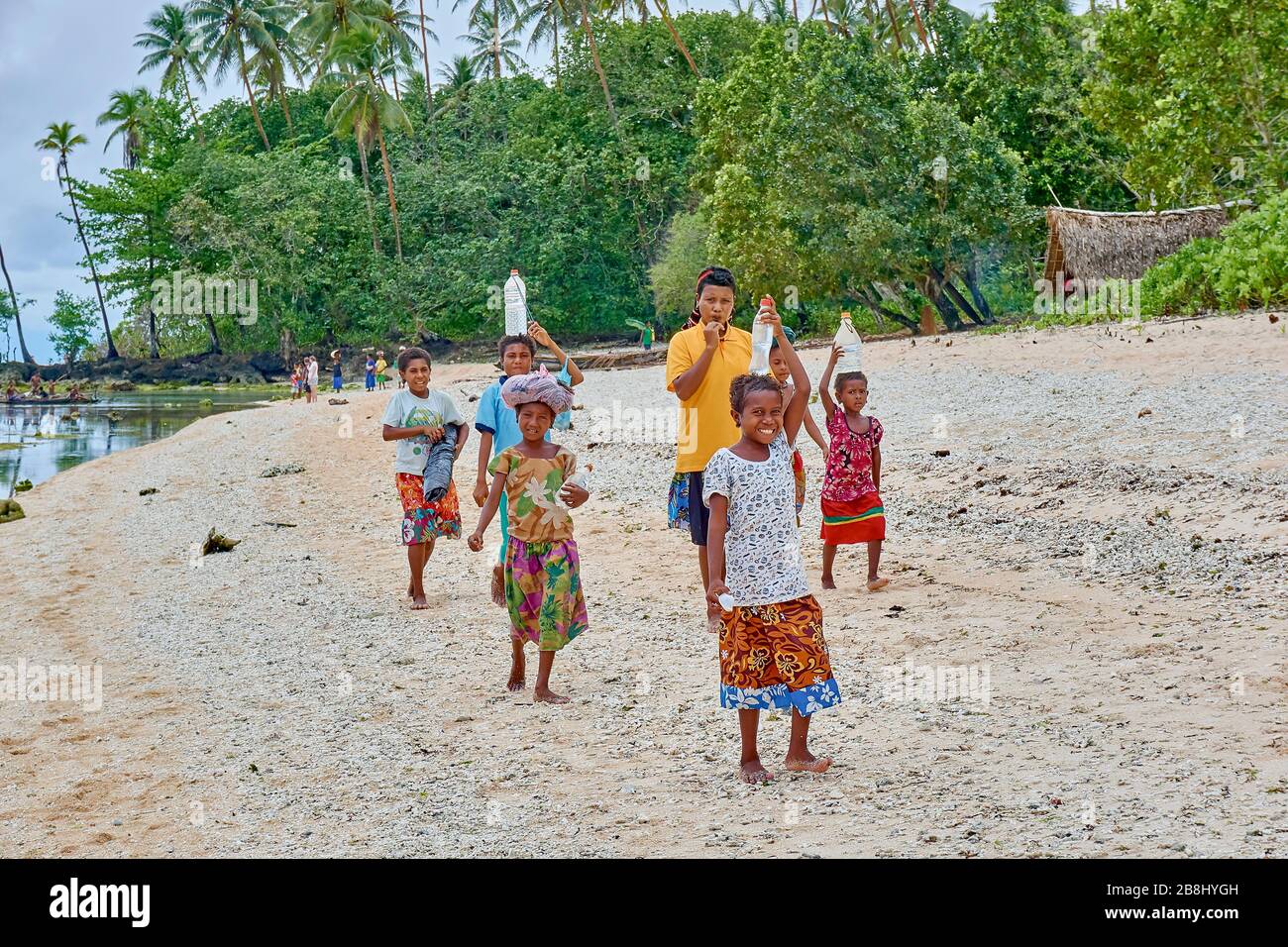 Femme marchant le long de l'artère de la plage portant le fardeau sur leurs têtes Native Entrepreneur Village Femme Femme Femme Femme Jeune adolescent Banque D'Images