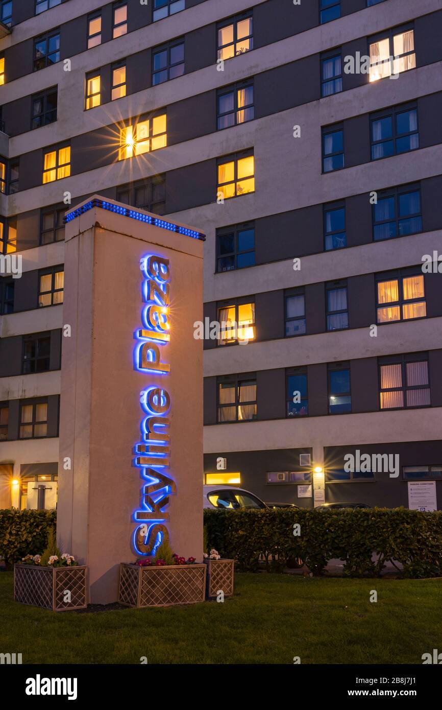Appartements illuminés la nuit à Skyline Plaza, un immeuble de bureaux rénové en hauteur - concept: Marché de location, vie verticale, investissement immobilier Banque D'Images