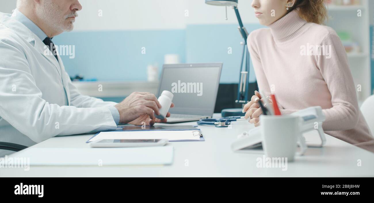 Médecin professionnel senior qui rencontre un patient au bureau et qui donne un médicament sur ordonnance Banque D'Images