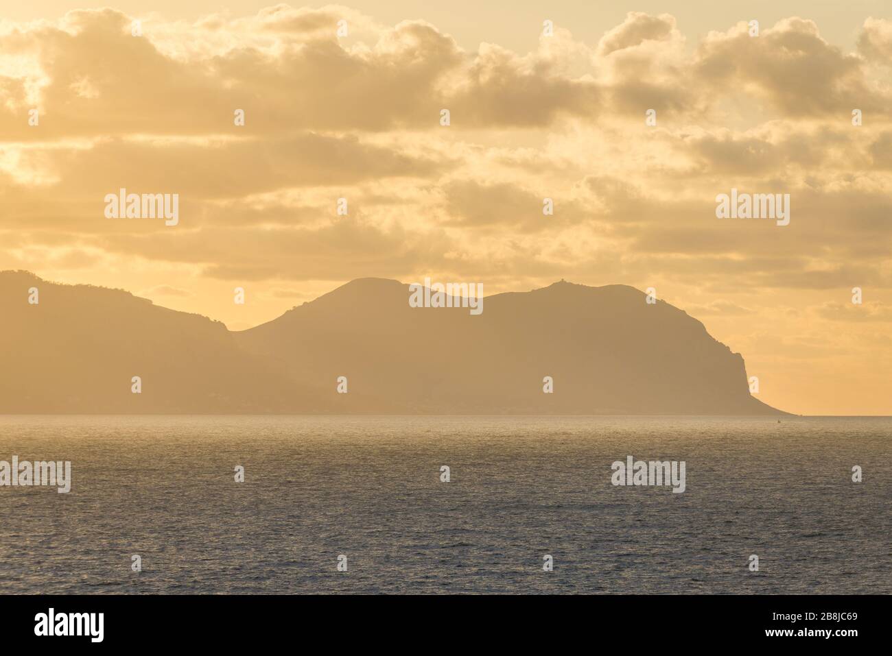 Coucher de soleil sur la mer Tyrrhénienne vue de Zafferano cape près de Santa Flavia sur l'île Sicile en Italie, Gallo cape et Pellegrino mont sur fond Banque D'Images