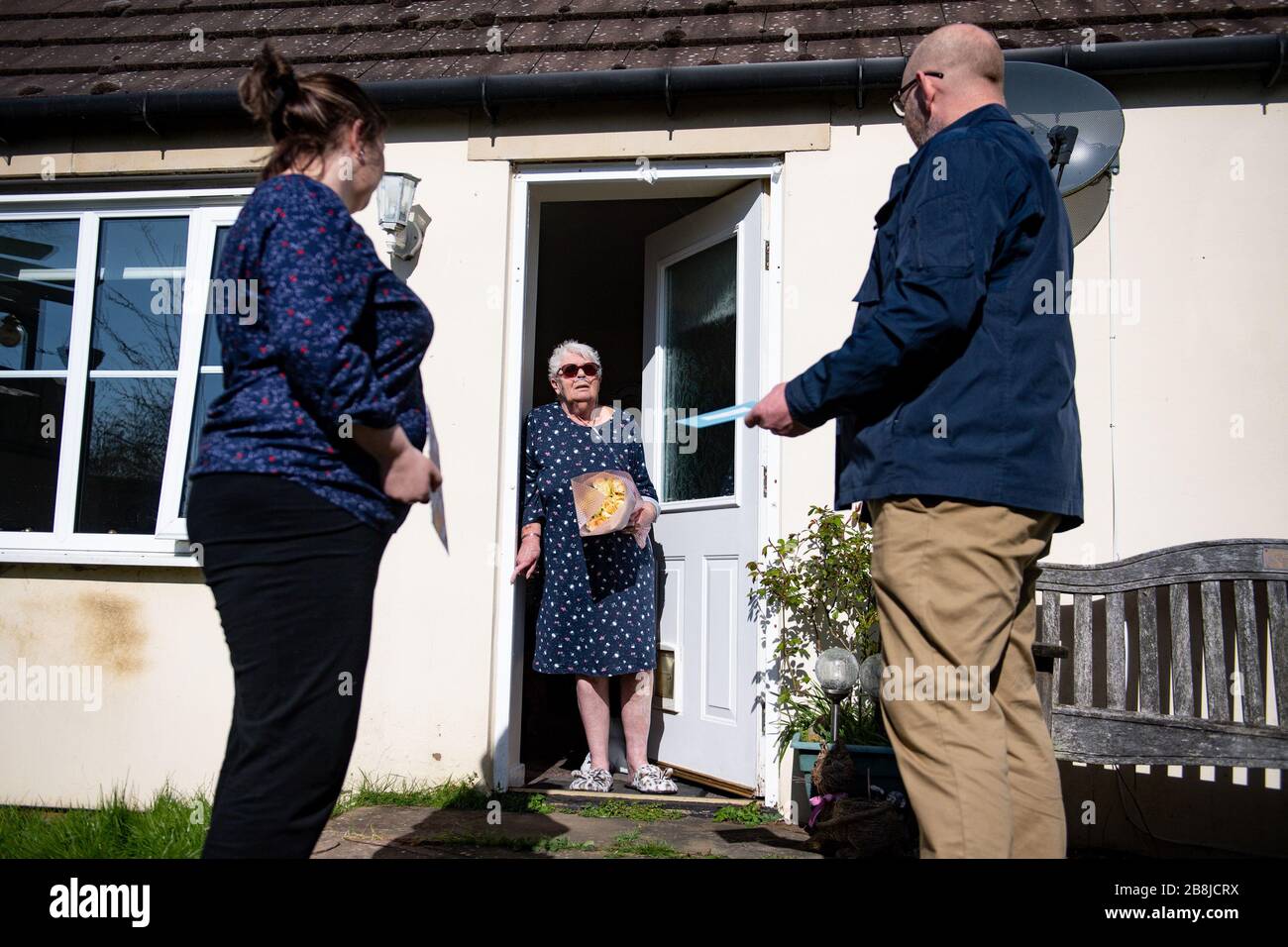 Olive Trotman, 76 ans, est visité le jour de la mère par son fils Mark Trotman et sa fille Kelly Trotman. L'olive souffre de la maladie pulmonaire obstructive chronique (MPOC) et de l'emphysème, et prend la précaution de communiquer à une distance sûre ou à travers une fenêtre de verre, afin de limiter la propagation potentielle du coronavirus. Date de la photo Dimanche 22 Mars 2020. Voir l'histoire de PA SANTÉ Coronavirus. Crédit photo devrait lire: Jacob King/PA fil Banque D'Images
