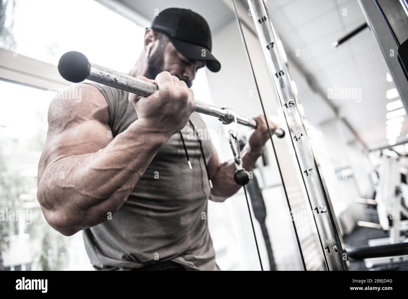 jeune homme musclé puissant avec barbe soulevant le poids lourd dans la salle de sport Banque D'Images
