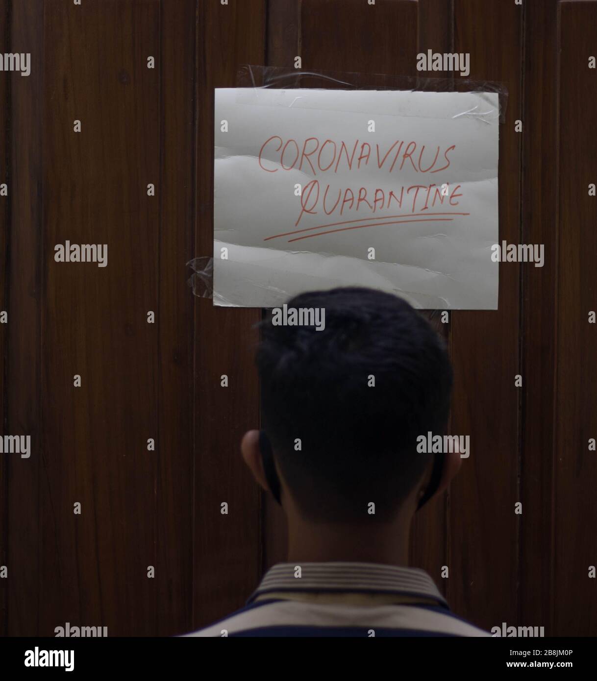 Coronavirus infecté Italien homme portant le masque de visage à la maison quarantaine avec le signe de quarantaine du coronavirus dans la porte.patient de Coronavirus à la maison qquaran Banque D'Images