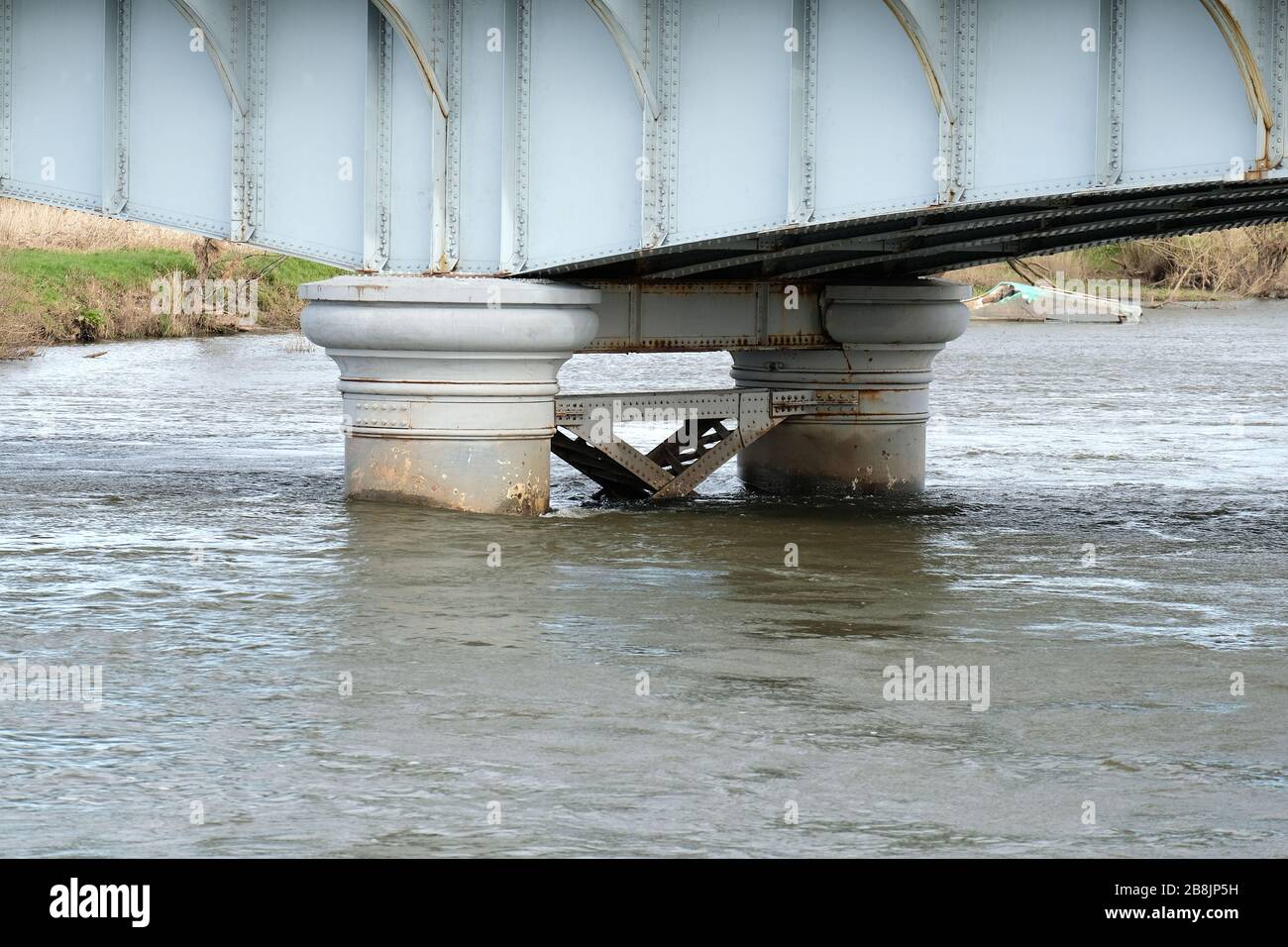 Pont en acier avec colonnes dans une rivière inondée Banque D'Images