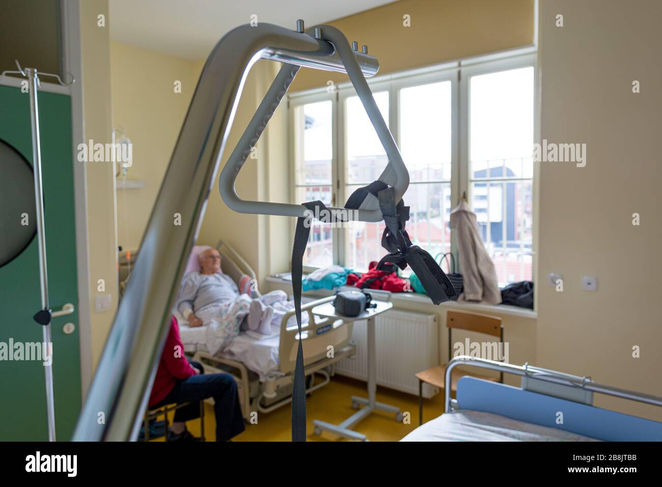 Triangle de lit d'hôpital avec couple de personnes âgées non  reconnaissables en arrière-plan Photo Stock - Alamy