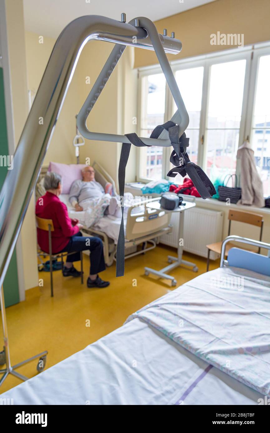 Triangle de lit d'hôpital avec couple de personnes âgées non  reconnaissables en arrière-plan Photo Stock - Alamy