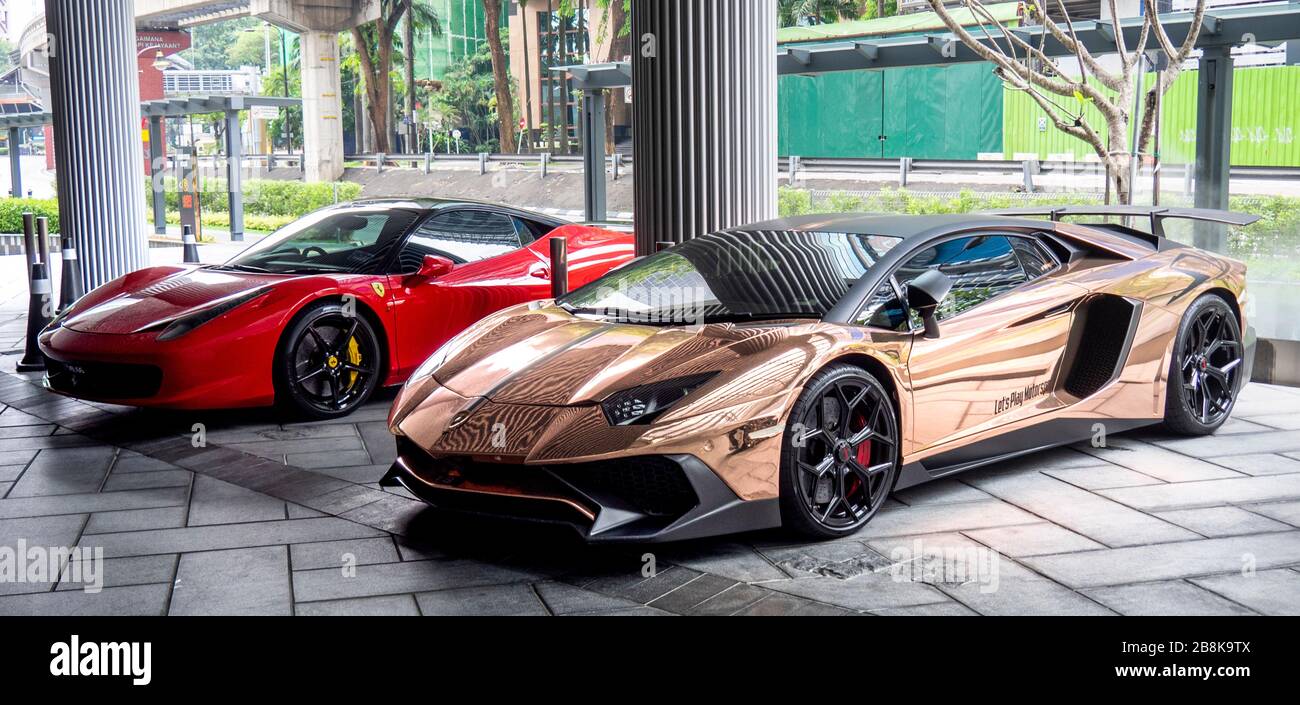 Ferrari 458 Italia et Lamborghini Aventador SV Roadster garés dans le foyer du bâtiment à Kuala Lumpur en Malaisie. Banque D'Images