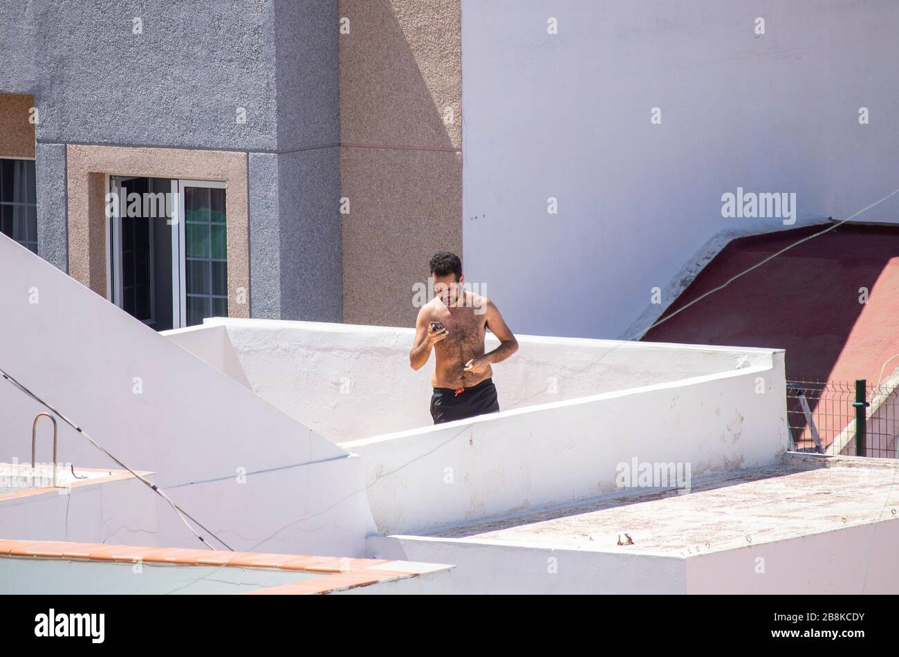Las Palmas, Grande Canarie, îles Canaries, Espagne. 22 mars 2020. Alors que l'Espagne termine sa première semaine d'un verrouillage strictement imposé, un homme se tourtera autour de la terrasse sur le toit de Gran Canaria. Le Premier ministre espagnol a annoncé dimanche que l'état d'urgence du dispositif de verrouillage/de quarantaine de Coronavirus serait prolongé jusqu'au 12 avril au plus tard. En dehors de l'Italie, l'Espagne a le taux d'infection/décès le plus élevé de Covid-19 en Europe. Crédit: Alan Dawson/Alay Live News Banque D'Images