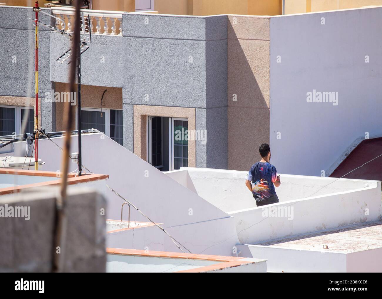 Las Palmas, Grande Canarie, îles Canaries, Espagne. 22 mars 2020. Alors que l'Espagne termine sa première semaine d'un verrouillage strictement imposé, un homme se tourtera autour de la terrasse sur le toit de Gran Canaria. Le Premier ministre espagnol a annoncé dimanche que l'état d'urgence du dispositif de verrouillage/de quarantaine de Coronavirus serait prolongé jusqu'au 12 avril au plus tard. En dehors de l'Italie, l'Espagne a le taux d'infection/décès le plus élevé de Covid-19 en Europe. Crédit: Alan Dawson/Alay Live News Banque D'Images