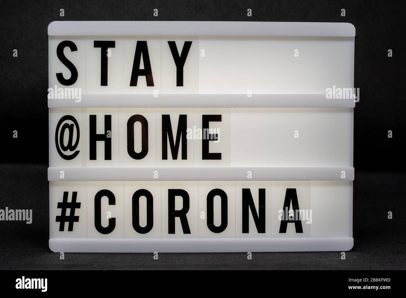 Est écrit sur un panneau lumineux avec des lettres noires: Rester à la  maison #Corona Photo Stock - Alamy