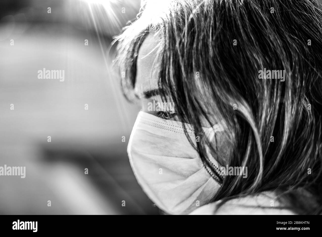 Virus Corona. Femme malade du virus corona regardant par la fenêtre et portant la protection respiratoire de sécurité et la récupération de la maladie à la maison. Pat Banque D'Images