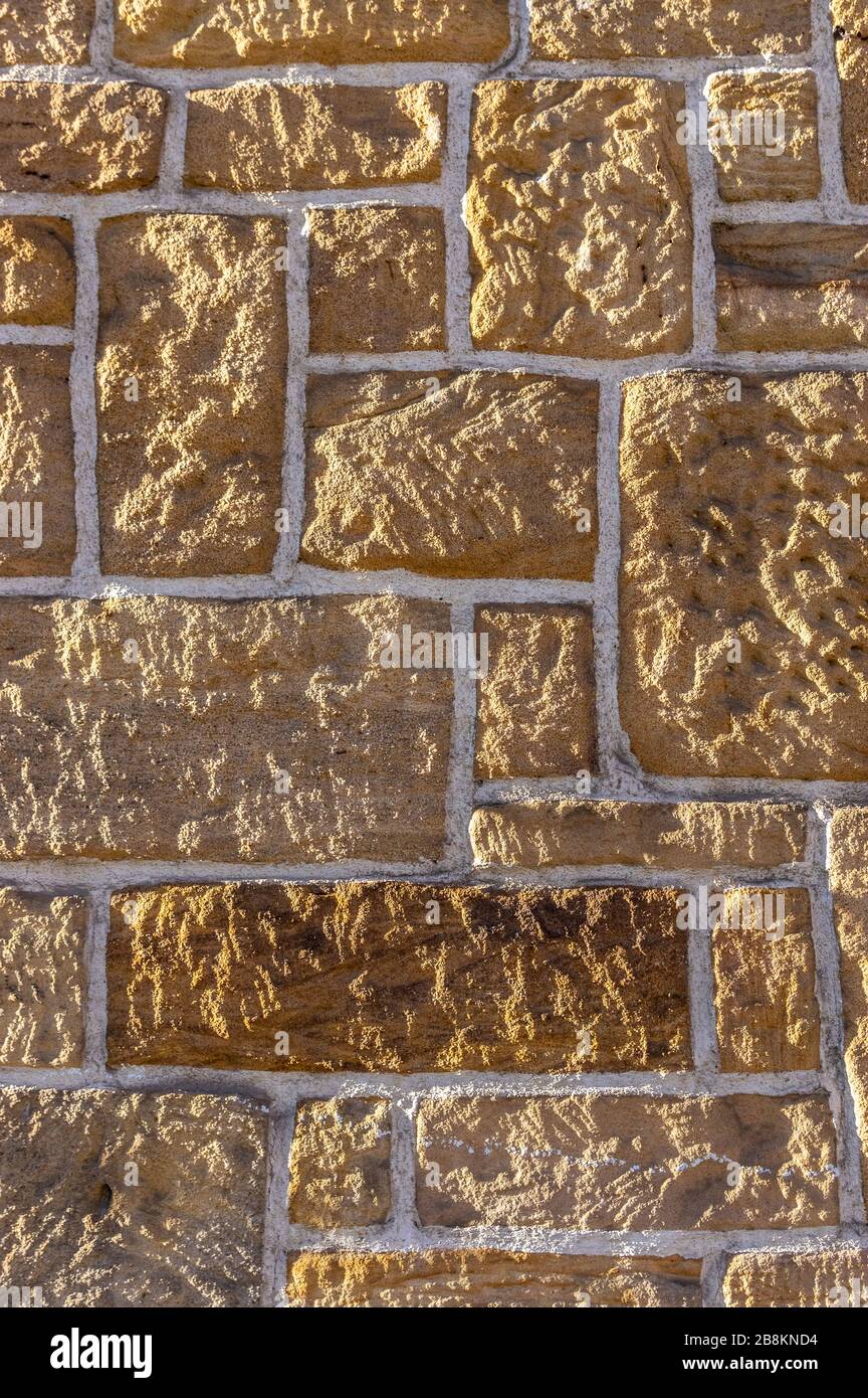 Mur de grès, bite avec des pierres rustiques et des joints blancs de différentes tailles aiguisées Banque D'Images