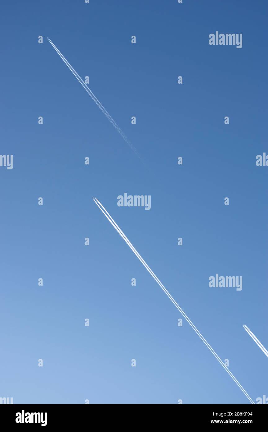 En regardant dans le ciel bleu clair et sans nuages avec 3 avions avec des contreseaux volant parallèle et décalés dans la même direction Banque D'Images
