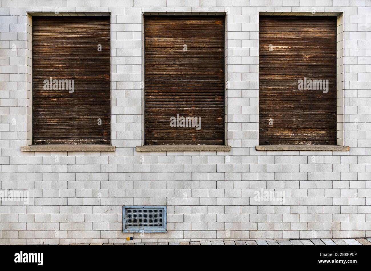 Façade carrelée, tissée avec soffit avec volets en bois fermés cousue et bas de caisse en béton à copeaux Banque D'Images
