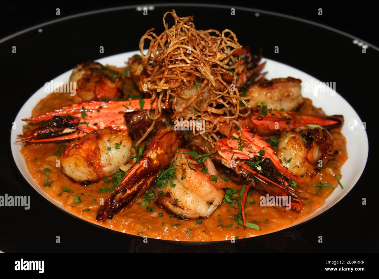 risotto grillé aux crevettes tigrées, riz italien cuit dans une sauce riche au homard de roche aromatisé Banque D'Images