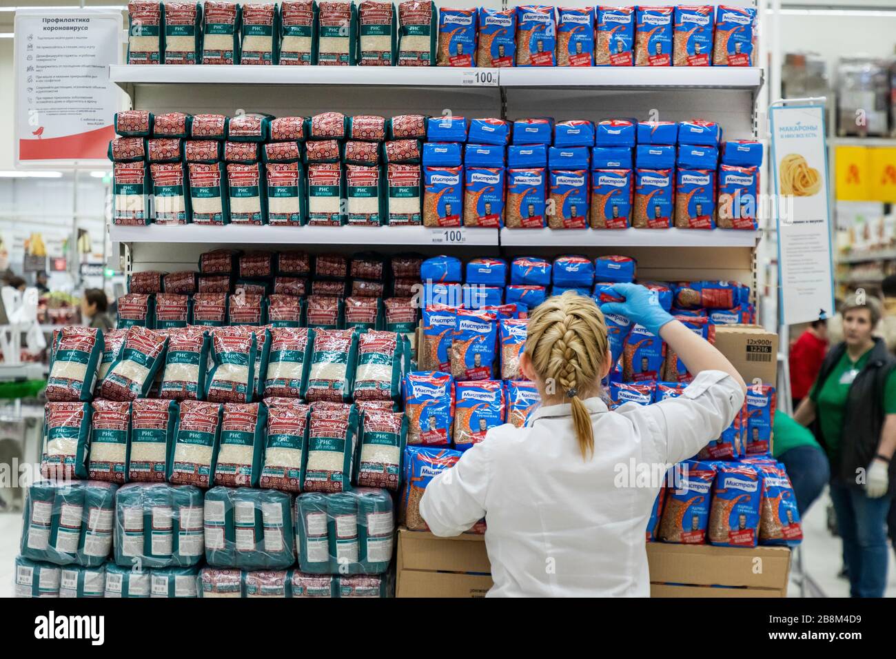 Moscou, Russie. 22 mars 2020 un employé du magasin présente des paquets de sarrasin (Grechka