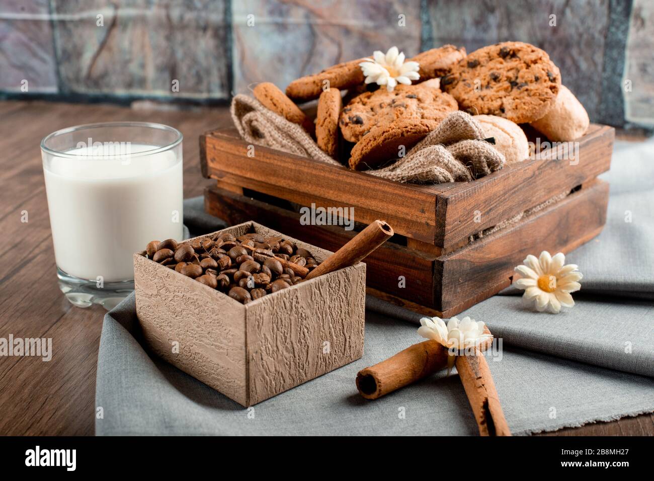 Boîte à biscuits douce et un verre de lait avec des grains de café Banque D'Images