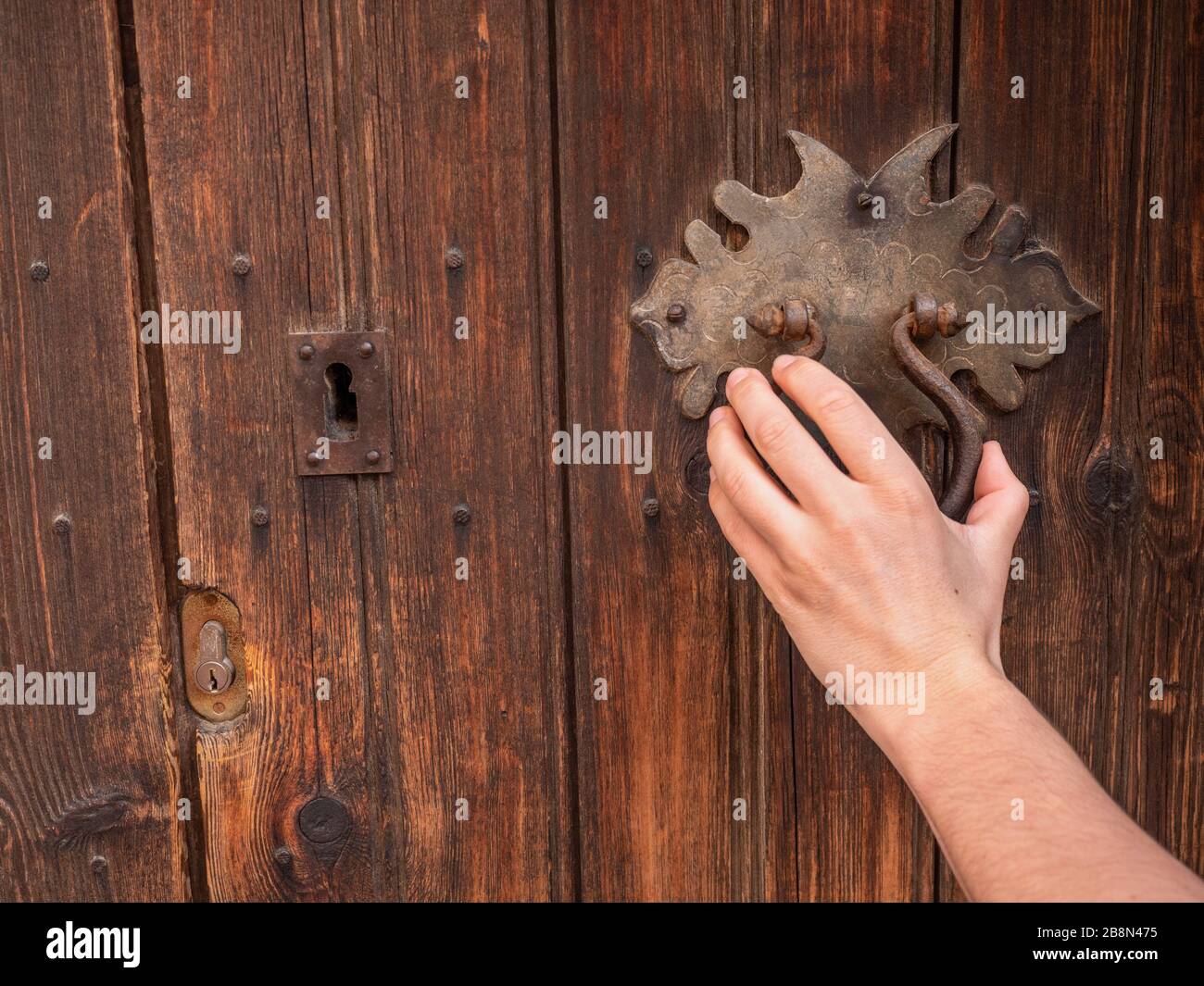 Ancien défonce en fer rouillé sur une ancienne porte en bois rétro. La main  frappe sur la porte. Femme cognant à la main sur une porte en bois Photo  Stock - Alamy