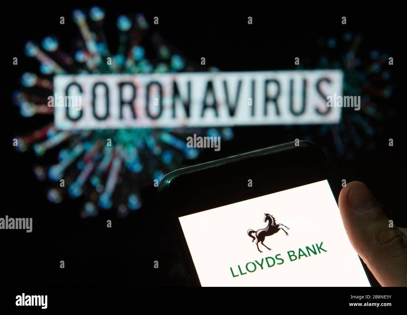 Chine. 20 mars 2020. Dans cette photo, le logo de la banque britannique de détail et de commerce Lloyds Banking Group s'affiche sur un smartphone avec un modèle d'ordinateur du coronavirus COVID-19 en arrière-plan. Crédit: Burul Chukrut/SOPA Images/ZUMA Wire/Alay Live News Banque D'Images