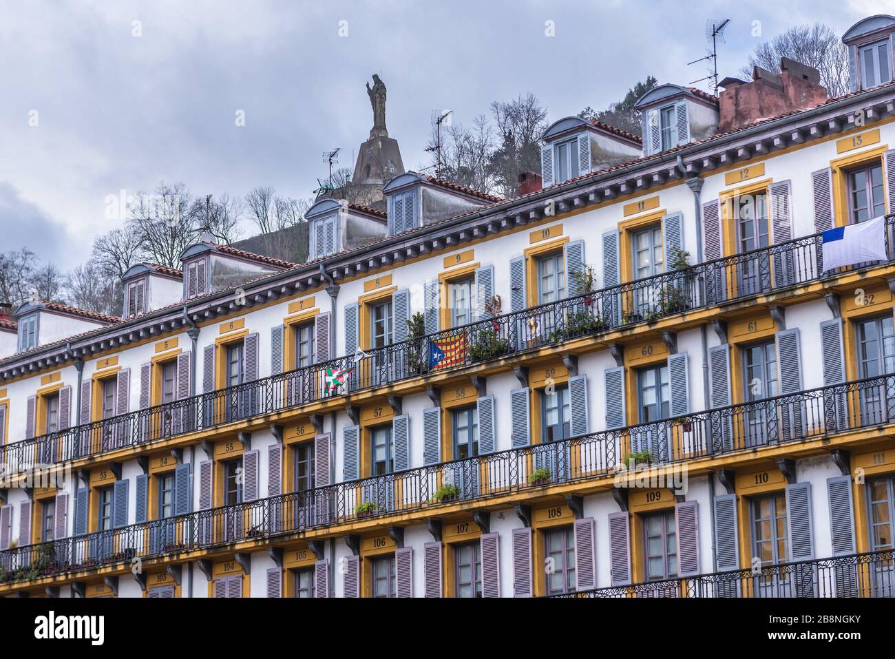 Bâtiment sur Constitucion Plaza dans la ville côtière de San Sebastian située dans la Communauté autonome basque, Espagne, vue avec la statue de Jésus sur le mont Urgull Banque D'Images