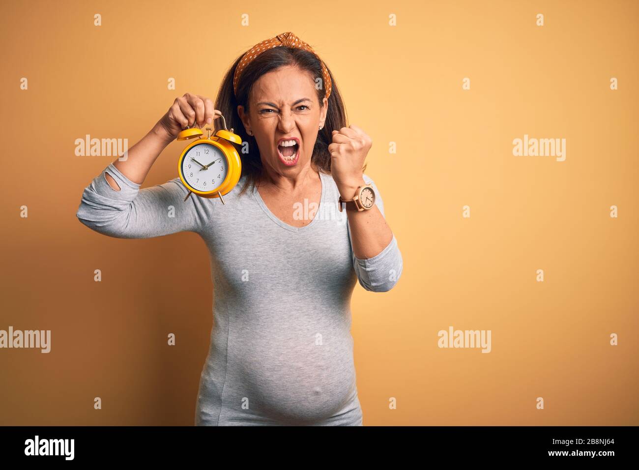 La Femme Enceinte D Age Moyen Qui Attend Un Bebe A Une Grossesse Agee Avec Un Reveil Agace Et Frustree De Crier Avec Colere Folle Et Affliger Avec Des Rais Photo Stock