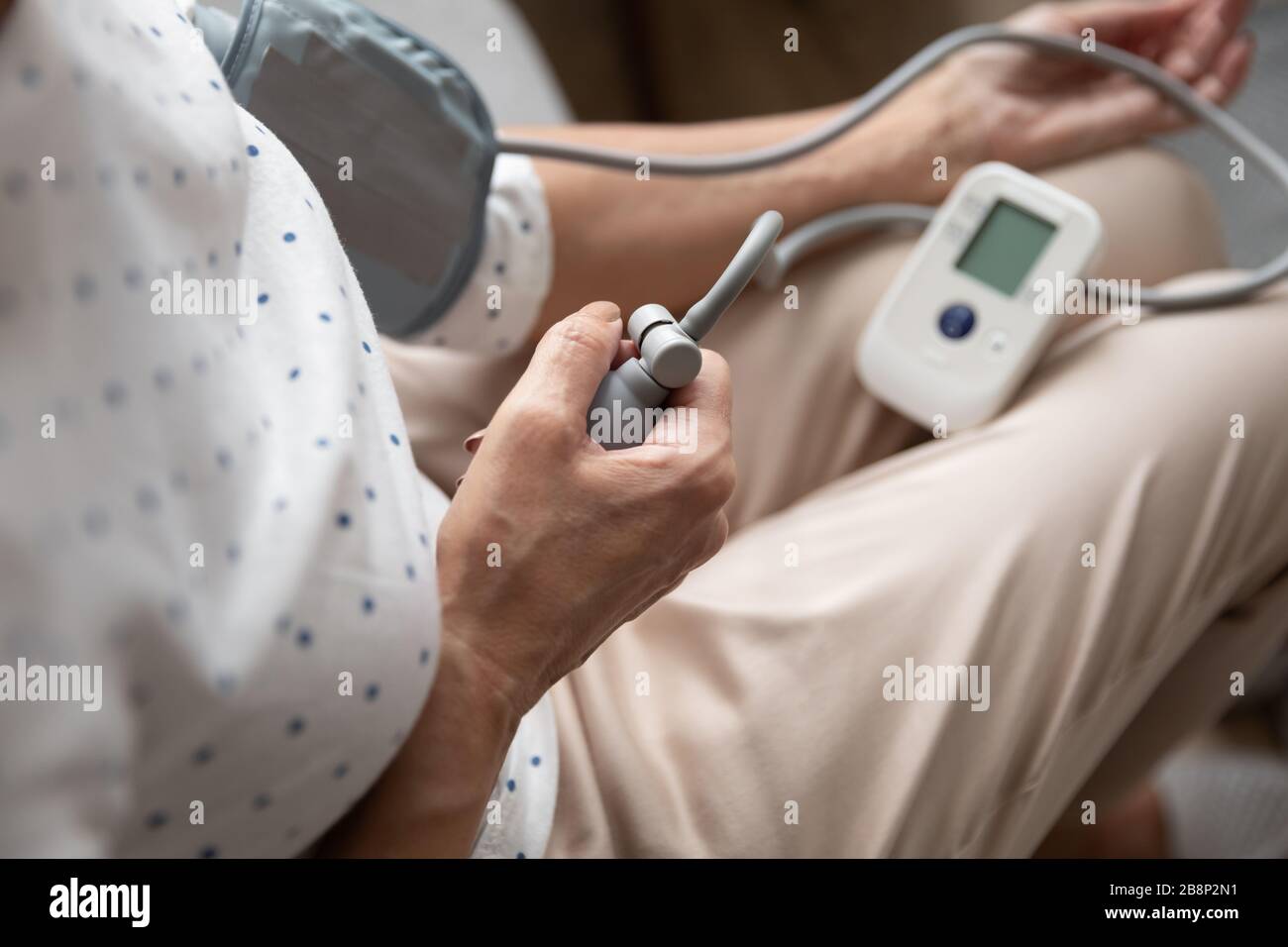 Gros plan sur une femme plus âgée à l'aide d'un sonomètre numérique semi-automatique. Banque D'Images