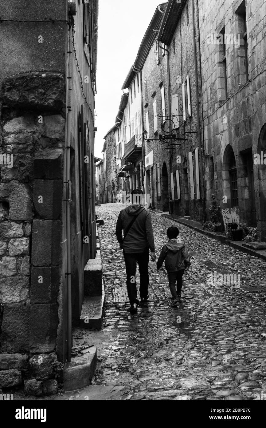 père et fils marchant sur une rue pavée vide Banque D'Images