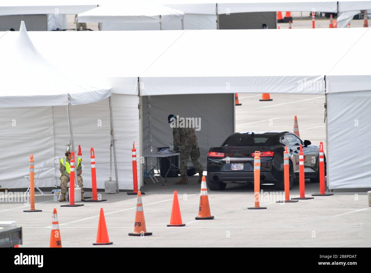 Miami Gardens, Floride, États-Unis. 23 mars 2020. Au lieu de se mettre en place pour le tournoi de tennis de Miami Open, la Garde nationale de Floride (beaucoup sans masques de visage en raison d'une pénurie) J'ai été en train de faire un essai en voiture au large de l'autoroute Florida Turnpike au Hard Rock Stadium de Miami Gardens, où les gens peuvent passer un test COVID-19 sans sortir de leur voiture. Comme le nombre de cas de COVID-19 de Miami-Dade CountyÕs atteint 169, le site sera ouvert lundi à 9 heures dans le parking est du Hard Rock Stadium, 347 Don Shula Drive. Crédit: Groupe médias de tempêtes/Alay Live News Banque D'Images