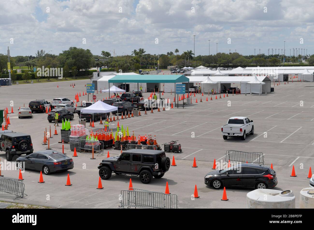 Miami Gardens, Floride, États-Unis. 23 mars 2020. Au lieu de se mettre en place pour le tournoi de tennis de Miami Open, la Garde nationale de Floride (beaucoup sans masques de visage en raison d'une pénurie) J'ai été en train de faire un essai en voiture au large de l'autoroute Florida Turnpike au Hard Rock Stadium de Miami Gardens, où les gens peuvent passer un test COVID-19 sans sortir de leur voiture. Comme le nombre de cas de COVID-19 de Miami-Dade CountyÕs atteint 169, le site sera ouvert lundi à 9 heures dans le parking est du Hard Rock Stadium, 347 Don Shula Drive. Crédit: Groupe médias de tempêtes/Alay Live News Banque D'Images