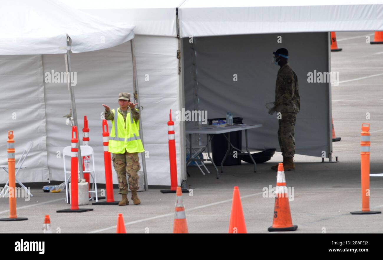 Miami Gardens, Floride, États-Unis. 23 mars 2020. Au lieu de se mettre en place pour le tournoi de tennis de Miami Open, la Garde nationale de Floride (beaucoup sans masques de visage en raison d'une pénurie) J'ai été en train de faire un essai en voiture au large de l'autoroute Florida Turnpike au Hard Rock Stadium de Miami Gardens, où les gens peuvent passer un test COVID-19 sans sortir de leur voiture. Comme le nombre de cas de COVID-19 de Miami-Dade CountyÕs atteint 169, le site sera ouvert lundi à 9 heures dans le parking est du Hard Rock Stadium, 347 Don Shula Drive. Crédit: Groupe médias de tempêtes/Alay Live News Banque D'Images