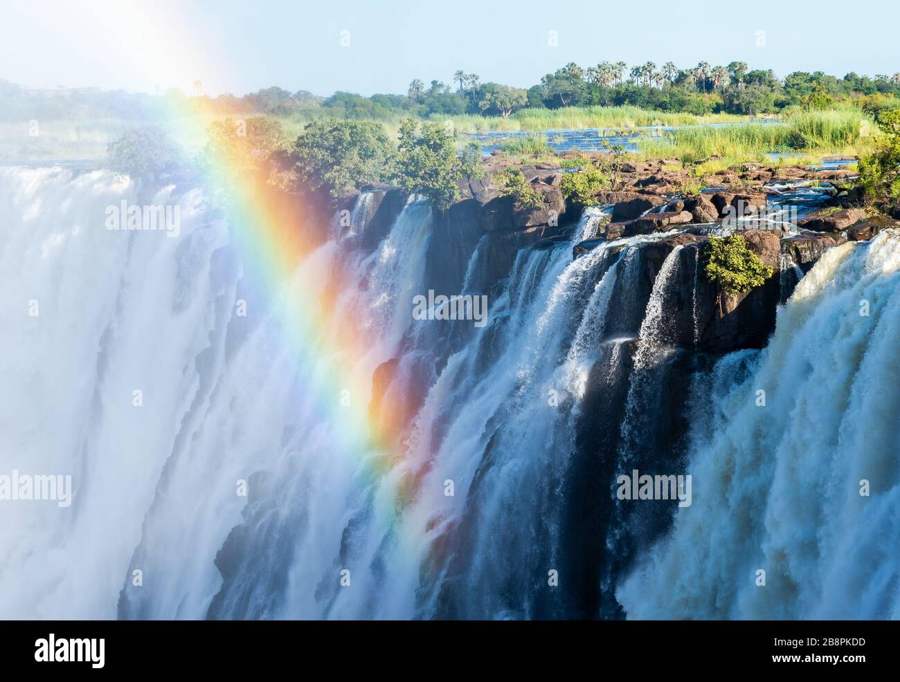 Rainbow en face de l'eau qui coule de la rivière Zambèze aux chutes Victoria, site classé au patrimoine mondial de l'UNESCO à la frontière entre la Zambie et le Zimbabwe. Banque D'Images