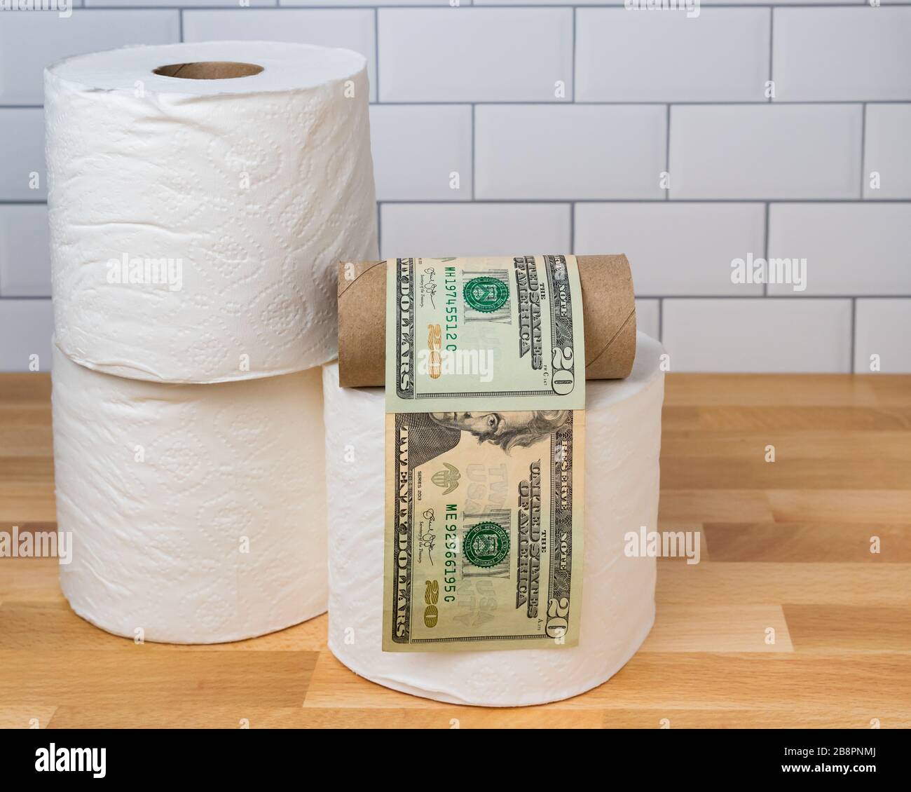 Rouleau de papier toilette vide enveloppé dans des factures de 20 dollars. Concept de pénurie d'approvisionnement, de ralentissement, de gougeage des prix pendant la pandémie mondiale de coronavirus Covid-19 Banque D'Images