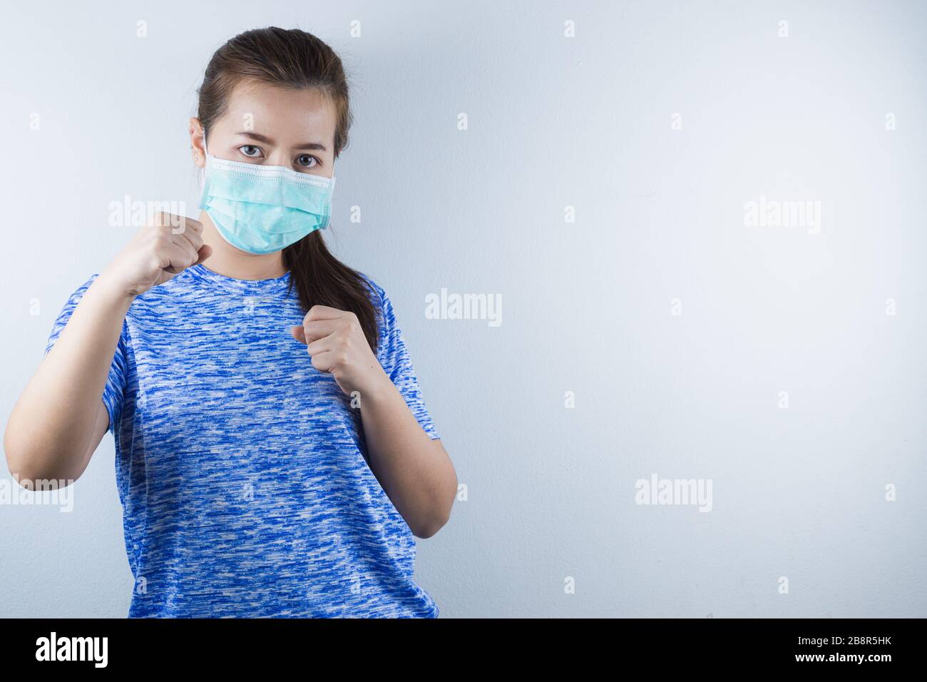 Une fille portant un masque pour protéger le coronavirus, pm 2.5 et allergique à la fourrure de chat et montrer sa main pour les combattre. Coronavirus et pollution atmosphérique pm 2 Banque D'Images