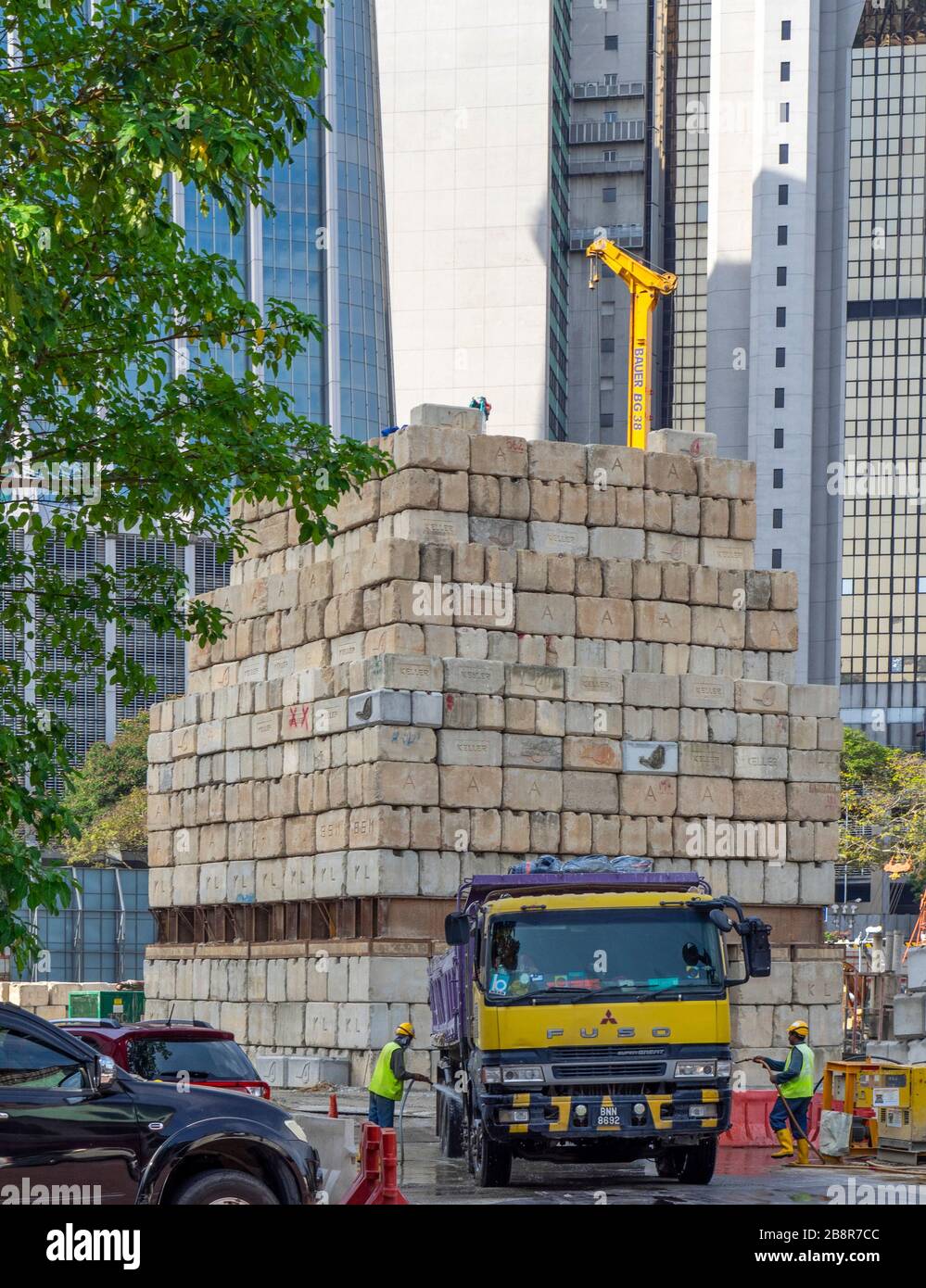 Des blocs de ciment de chantier sont mis en place comme contrepoids pour une grue et un camion a été déraclé par deux ouvriers Kuala Lumpur Malaisie. Banque D'Images