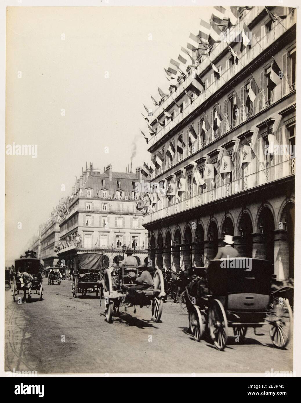 Rue de Rivoli 14 juillet 1888 entre la place du Palais Royal / et la rue du Louvre. Drapeaux sur les façades de la rue de Rivoli au 14 juillet 1888, entre la place du Palais Royal et la rue du Louvre, 1ère arrondissement, Paris 'Drateaux sur les façades de la rue de Rivoli pour le 14 juillet 1888, entrée de la place du Palais-Royal et de la rue du Louvre, Paris (Er arr.)'. Photo d'Hippolyte Blancard (1843-1924). 1888. Paris, musée Carnavalet. Banque D'Images