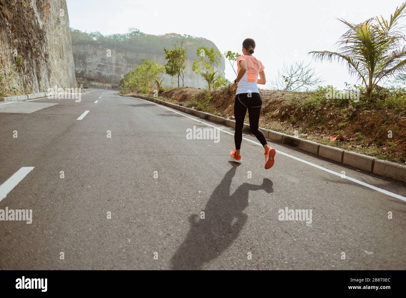 femme de sport courir sur sideroad. femme de sport courir sur la route vide Banque D'Images